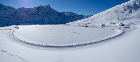 Passo del Tonale, Italy. Artificial water catchment reservoir for snow skiing slopes. Winter time. Frozen lakeの写真素材