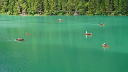 Amazing view of the famous Braies Lake in Italy. People row the traditional boats made of wood. Alpine lake. Picturesque mountain lake in Dolomites. Wonderful nature contest. Touristic destinationのeditorial素材