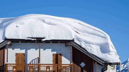 The roof of an house or hotel covered by massive quantity of fresh snow after heavy snowfall. Mountain and winter contest. Italian alpsのeditorial素材