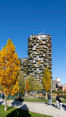 Milan, Italy. Bosco Verticale, view at the modern and ecological skyscraper with many trees on each balcony. Modern architecture, vertical gardens, terraces with plants. Fall season. Warm colorsのeditorial素材