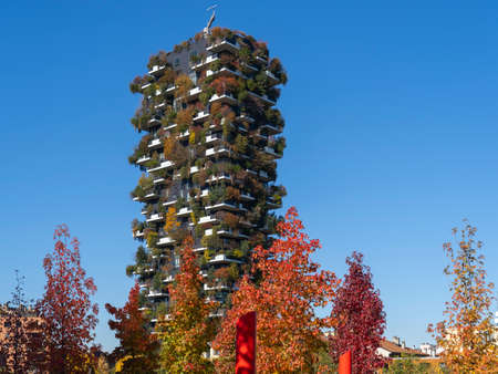 Milan, Italy. Bosco Verticale, view at the modern and ecological skyscraper with many trees on each balcony. Modern architecture, vertical gardens, terraces with plants. Fall season. Warm colorsのeditorial素材