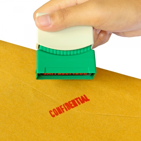 Holding a confidential stamper isolated over white backgroundの写真素材