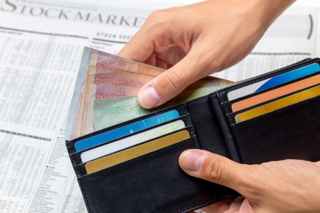 Took the money out of pocket over stock market newspaper background