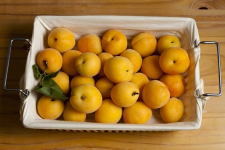 Apricots in a Basket on Woodの写真素材