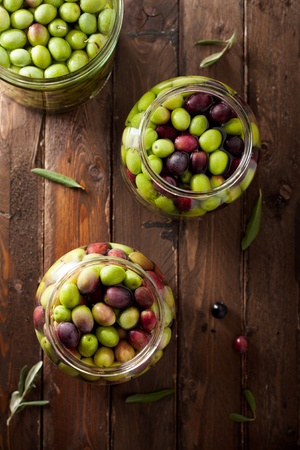 Olives in Brine (with Water and Salt in Glass Jars) on Woodの写真素材