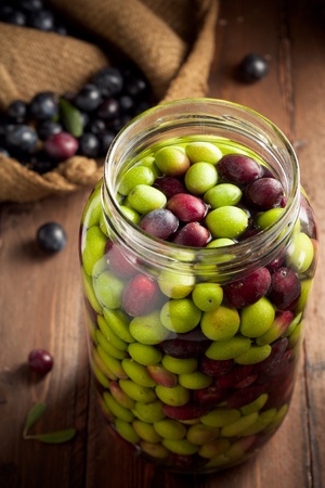 Olives in Brine (with Water and Salt in Glass Jar) on Woodの写真素材