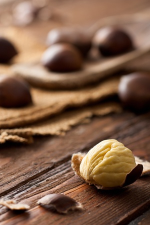Raw Chestnuts on Wood with Jute and Wooden Spoonの写真素材