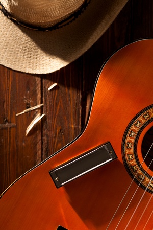 Harmonica on Guitar with Cowboy Hat on Woodの写真素材