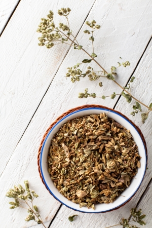 Dried Oregano in a Bowl on White Woodの写真素材