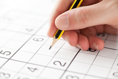 Hand with a Pencil Playing Sudokuの写真素材