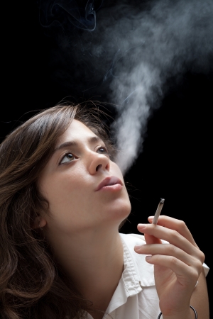 Woman Smoking a Cigarette on Black Backgroundの写真素材