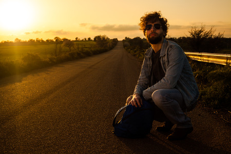 On the Road Traveler Crouching with Bagの写真素材