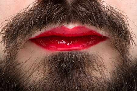 Man's Mouth with Red Lipstick on His Lips and Brown Beardの写真素材