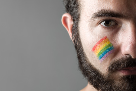 Man with Rainbow Painted on His Cheek, Symbol of Gay Rightsの写真素材