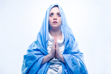 Virgin Mary with Blue Veil Praying on White Backgroundの写真素材