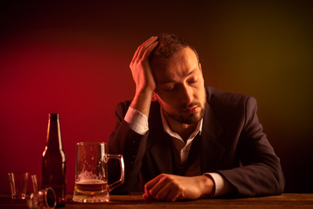Drunk Sad Businessman Sleeping in a Barの写真素材