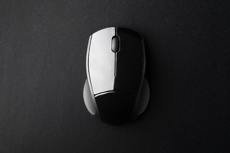 Black Wireless Optical Mouse on Black Surface Seen from Above