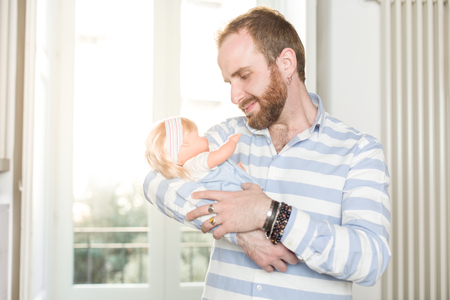 Smiling Redhead Man with Beard  Cradling a Dollの写真素材