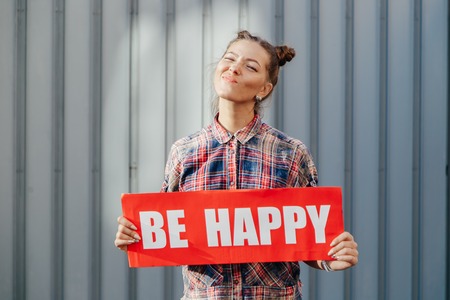 Pretty cheerful woman gesturing with fingers and showing awayの写真素材