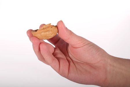 A hand holding the shell of a walnut.の写真素材