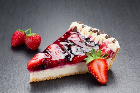 Strawberry cheesecake slice close up on a dark backgroundの写真素材