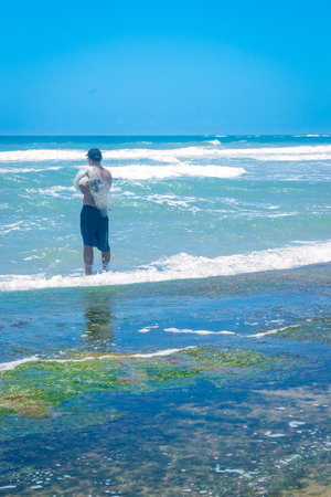 Young man standing in sea waterの写真素材