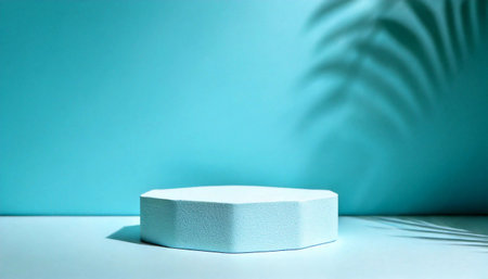 A minimalist hexagonal product podium on an aquamarine background, with a soft shadow of a palm frond. This clean and modern display is perfect for showcasing skincare, jewelry, or other luxury items.の素材