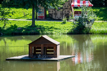 Small wooden house on a small lake in the city park in summerの写真素材