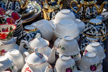 painted pottery, teapots cups and saucers and pots lie on the table for saleの写真素材