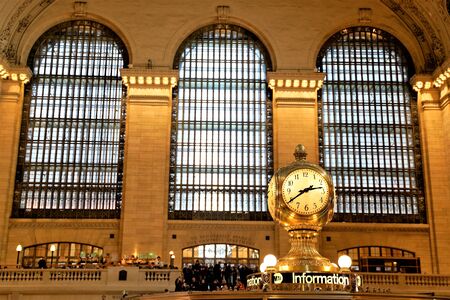 New York, New York, USA. March 16 2019. Interior of Main Concourse of Grand Central Terminal with the Clock and people walking around. Beautiful windows in the background.のeditorial素材