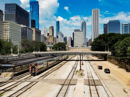 Chicago, Illinois, USA. 07 05 2018. Chicago landscape with train on a railroad and cars on a road in front.のeditorial素材