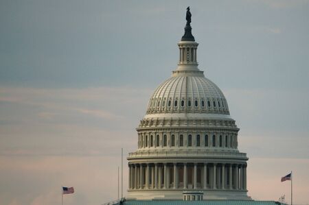 Washington, DC, USA. 08 18 2018. US Capitol dome with two flying flags at dawn or twilight.のeditorial素材
