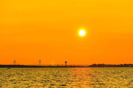 Orange dusk in evening in New York with Verrazzano-Narrows bridge view.の写真素材