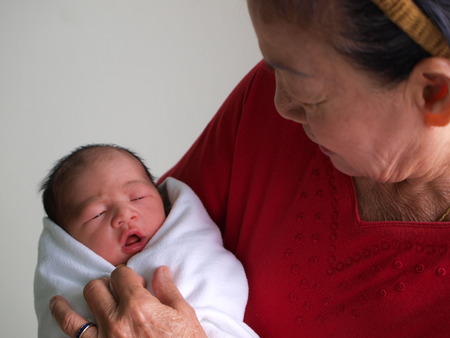 Newborn baby in the hand of his grandmother.