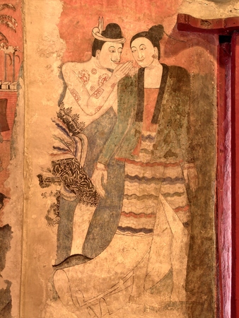 The famous mural painting of a man whispering to the ear of a woman in ancient Buddhist temple - Wat Phumin, Nan province, Thailand. The temple is open to the public.のeditorial素材