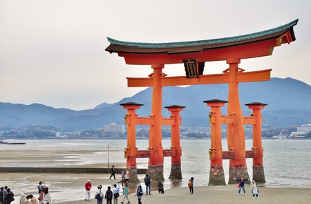HIROSHIMA, JAPAN - APRIL 11, 2014: Many unidentified people visit famous great Torii gate at Itsukushima island in Hiroshima, Japan. This island is popularly known as Miyajima.のeditorial素材