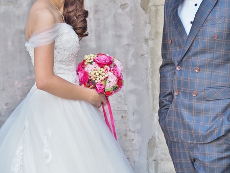 Bridal bouquet. Beautiful wedding bouquet. Wedding couple hugging, the beautiful bride holds a wedding bouquet next to the elegant groom.の写真素材