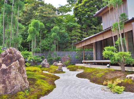 Kanagawa, Japan - June 9, 2017: Gravel path, stone lantern, stones and wooden building in Japanese...