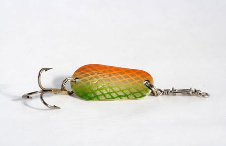 Spoon bait is dyed green color with hook on white background