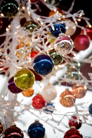 Hanging Christmas decorations in multiple colors and lightsの写真素材