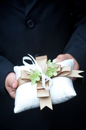 ring bearer holding the wedding rings on a pillowの写真素材