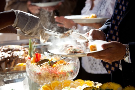 wedding food being served at a buffet table during a catered event  slight movement shows action の写真素材
