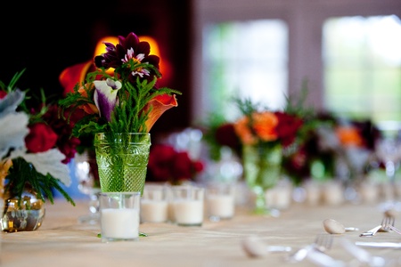 a small wedding centerpiece of flowers in a green vase