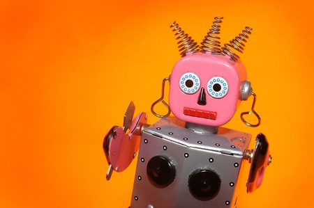 a pink and silver toy maid robot with an orange backgroundの写真素材