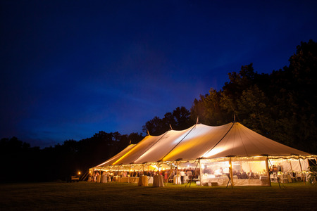 An event tent in a field at night during a wedding. glowing from withinの写真素材