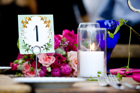 Table 1 and a bouquet of flowers with a lit candle during a wedding celebrationの写真素材