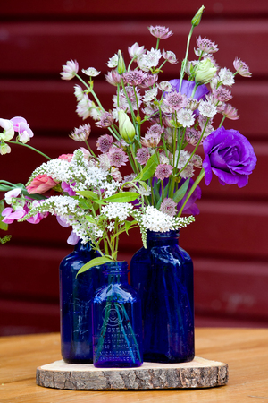 Wedding flower arrangement series. Bouquet of flowers for a wedding event in blue bottlesの写真素材