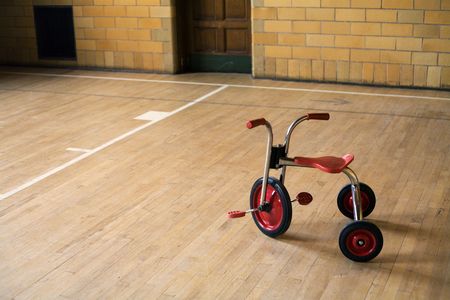 Old tricycle in and empty lonely old gymの写真素材