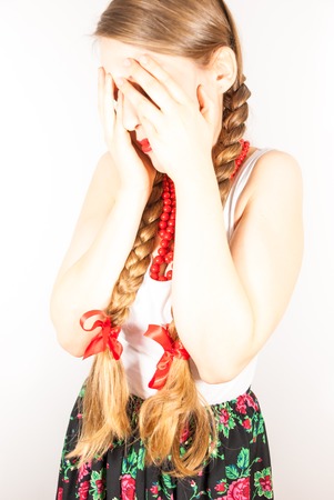 A young shy folk woman with long blonde tressesの写真素材
