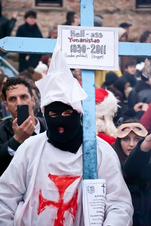 VEVCANI, MACEDONIA - JANUARY 13, 2012: A masked participant with a cross at Vevcani Carnival,...